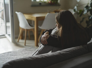 Sad woman sitting at the sofa with depression